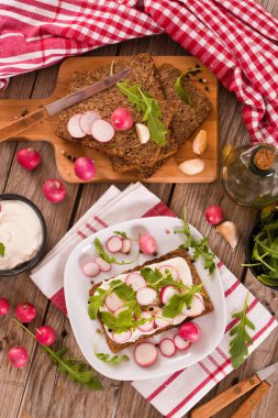 Çavdar ekmeği, süzme peynir, turp ve roka..