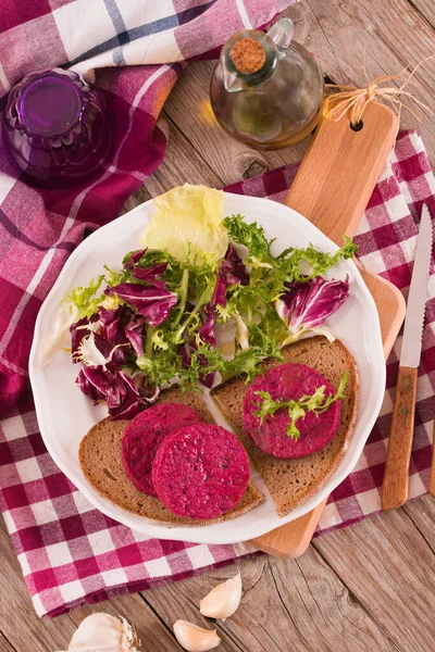 Beetroot veggie burger on white dish.