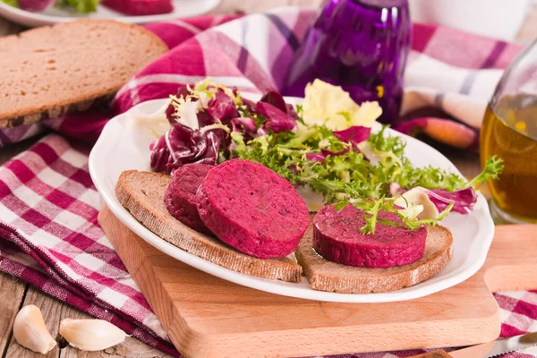 Beetroot veggie burger on white dish.