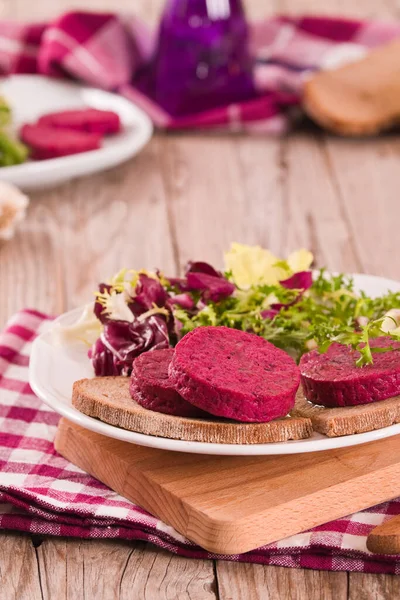 Beetroot veggie burger on white dish.