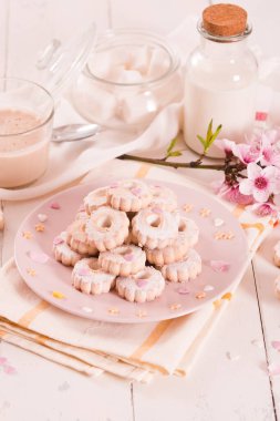 Canestrelli biscuits with icing sugar on pink dish. 
