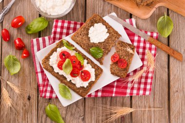 Çavdar ekmeği, süzme peynir, fesleğen ve domates..