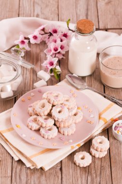 Canestrelli biscuits with icing sugar on pink dish. 