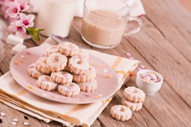 Canestrelli biscuits with icing sugar on pink dish. 