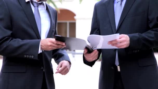 Businessman showing a file to his colleague — Stock Video