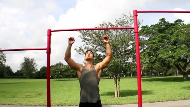 Framifrån. stilig atletisk kille drar på baren. pull ups — Stockvideo