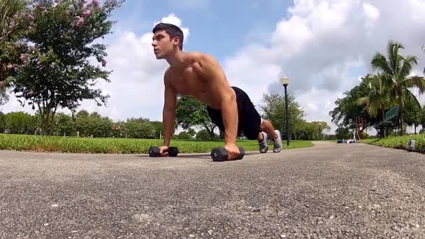 Hombre en ropa deportiva haciendo flexiones. Entrenamiento al aire libre — Vídeos de Stock