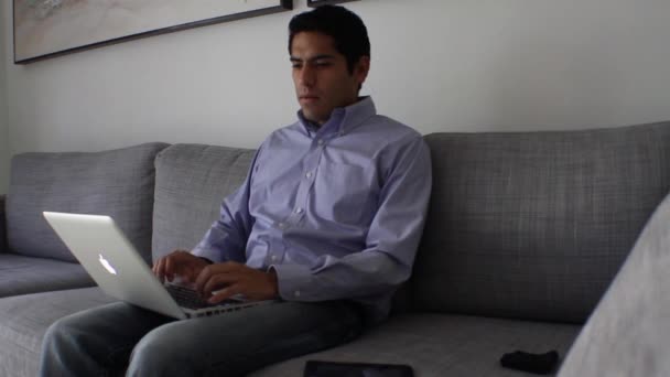 商务男人坐在沙发上的一台笔记本电脑在工作 — 图库视频影像