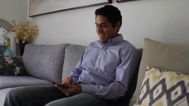 Hombre guapo en casa usando tableta — Vídeo de stock