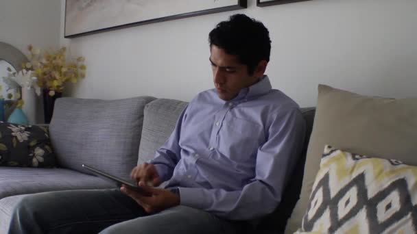 Pohledný muž doma pomocí tabletu — Stock video