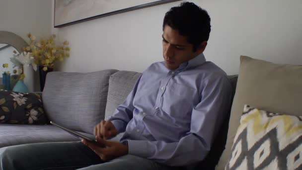 Hombre guapo en casa usando tableta — Vídeo de stock