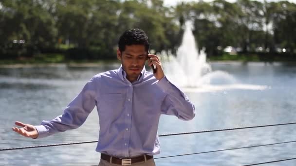 Злой бизнесмен разговаривает по телефону. на открытом воздухе — стоковое видео