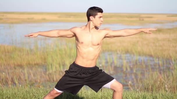 Junger Mann beim Yoga. friedliche Umgebung. im Freien — Stockvideo