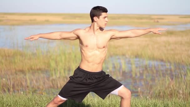 Young man doing yoga. Peaceful environment. Outdoors — Stock Video