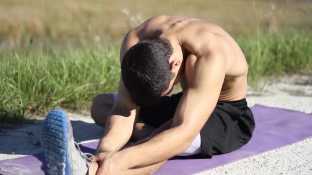 Homme s'étirant sur un tapis de fitness — Video