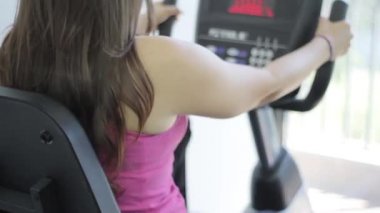 kadın bir spor salonunda sabit bir bisiklet üzerinde egzersiz