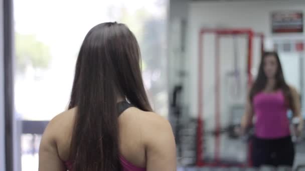 Frumoasă femeie ridicând greutăţi. Sala de sport — Videoclip de stoc