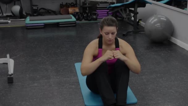 Mujer en ropa deportiva ejercitando abdominales en el gimnasio — Vídeos de Stock