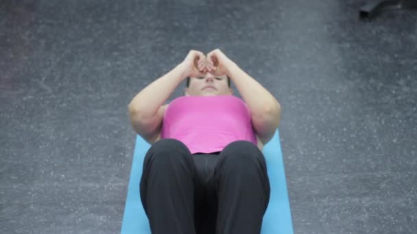 Femme en vêtements de sport exercice abdominaux dans la salle de gym — Video