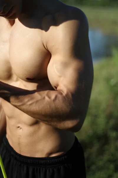 Musculoso super-hombre de alto nivel tira de las bandas de goma —  Fotos de Stock