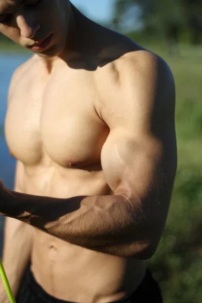 Muscular super-high level man pulls rubber bands. — Stock Photo, Image