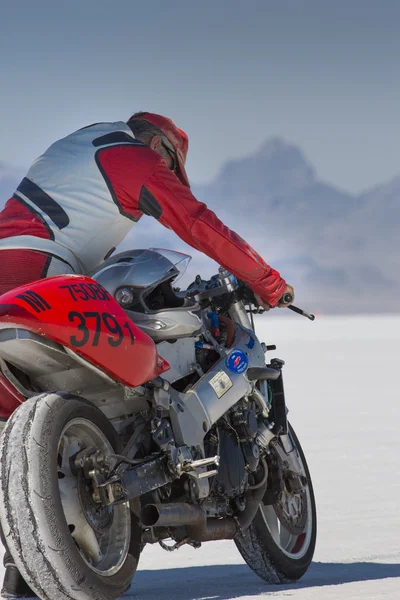 Un conductor no identificado sosteniendo su súper bicicleta durante el Mundo de la Velocidad en Bonneville Salt Flats —  Fotos de Stock