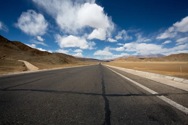 Straight road to Himalayas range, Tibet Royalty Free Stock Images