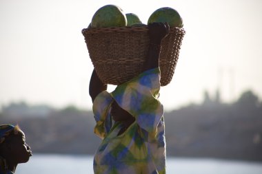 Woman carrying vegetables in Mopti clipart