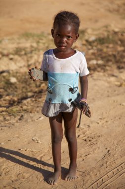 Young girl with a shoes in her hands in Mopti clipart