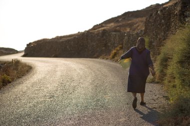 yaşlı kadın, folegandros sahil hattı, yolda yürürken
