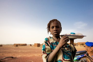 Girl selling food and water on the road to Mopti clipart