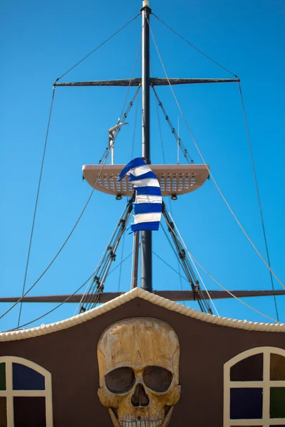 Pirate ship and broken greek flag in Rethymon — Stock Photo, Image