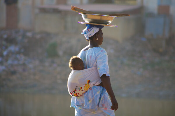 Woman carrying a baby in Mopti