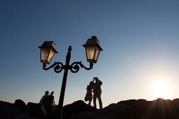 Casais tirando uma foto do mar Egeu ao pôr do sol — Fotografia de Stock