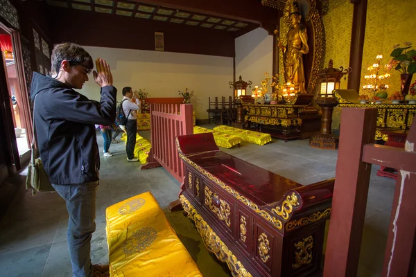 Europäischer Mann betet in einem Tempel in Hangzhou, China — Stockfoto