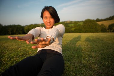 güzel Çinli kadın çimenlerin üzerinde yoga egzersizleri yapıyor