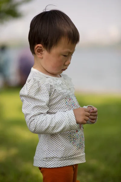 Niño pequeño en un parque en Hangzhou con un fondo borroso —  Fotos de Stock