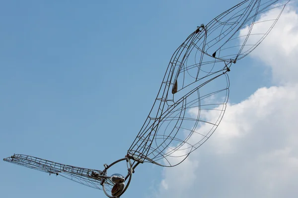 Δομή τέχνης μετάλλων πουλί με το γαλάζιο ουρανό και τα σύννεφα στο το backg — Φωτογραφία Αρχείου