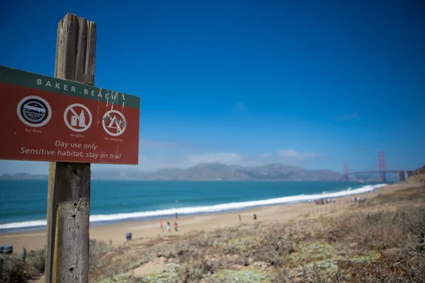 Szyld na plaży piekarz z mostu golden gate w plecy — Zdjęcie stockowe