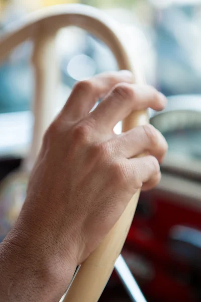 Närbild på en hand med en man med ratten på en vint — Stockfoto