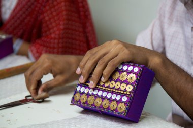 Hindistan'da mor ve dekore edilmiş bir kutu üzerinde çalışan eller Close-Up