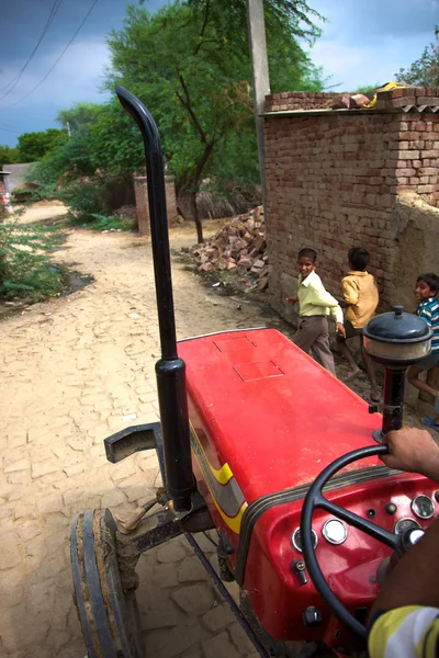 Red tractor and running kids — Stock Photo, Image