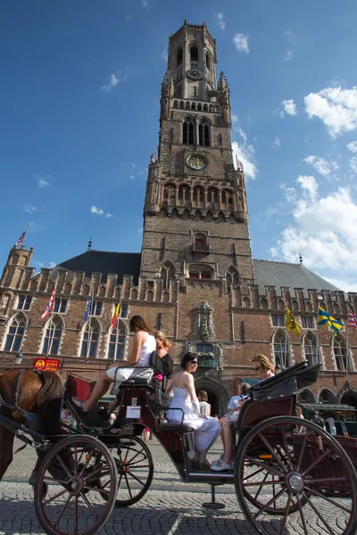 Gente en un tradicional carruaje de caballos en Brujas — Foto de Stock