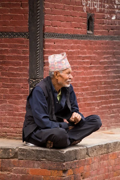 Velho descansando e observando a atividade de rua no Nepal — Fotografia de Stock