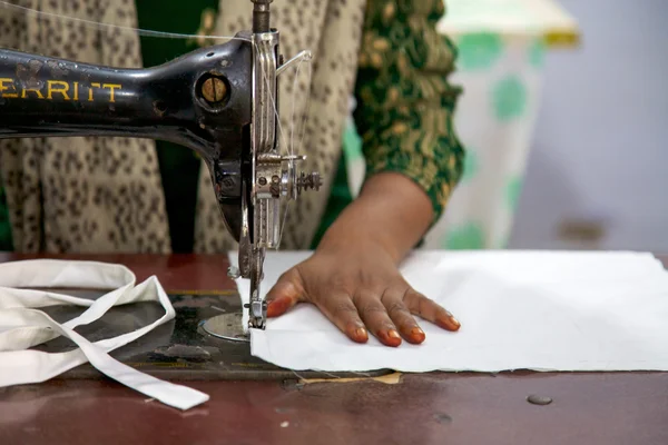 Unregnizable ambachtsman naaien verscheidene stukken van kleren in india — Stockfoto