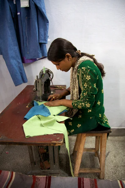 Woman sewing several pieces of clothes in Agra for Pushpanjali — Stock Photo, Image