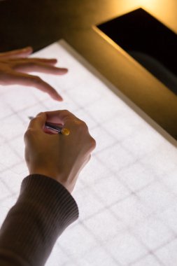 Beyaz arka plan ışığı tablo üzerinde sağ elinde siyah kalem