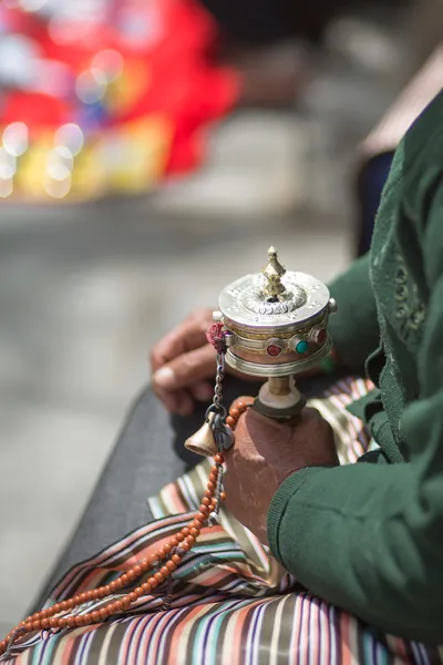 Gammal kvinna be med bön rulle i lhasa — Stockfoto