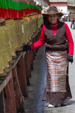 Tibetan pilgrim circles the Potala palace in Lhasa clipart