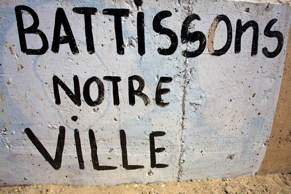 Umožňuje budovat naše město poselství na staré zdi v Senegalu — Stock fotografie